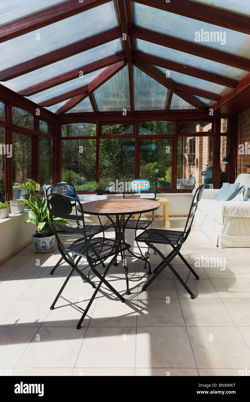conservatory tables chairs plants room in house next to garden Stock