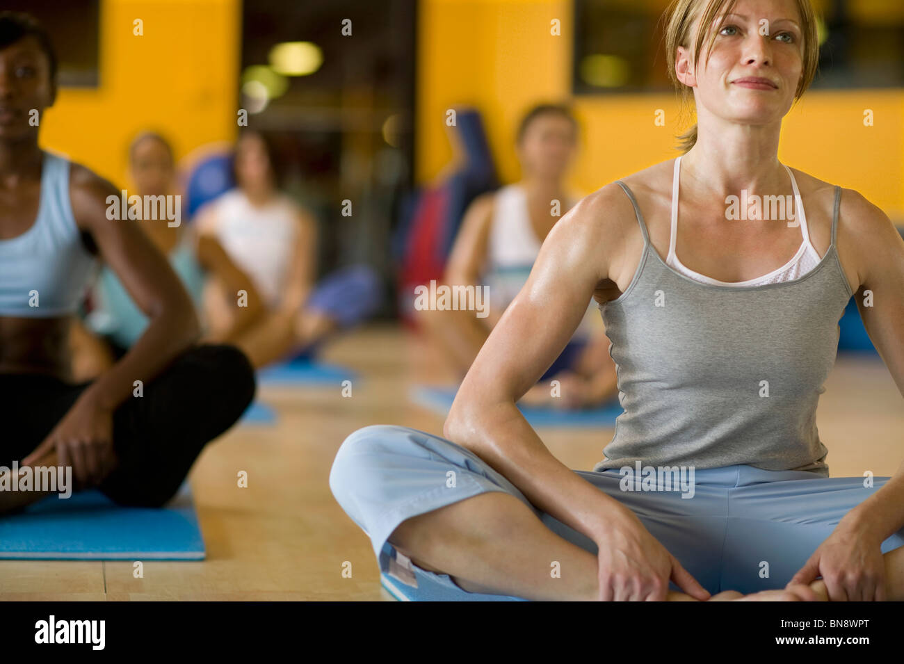 Women practicing yoga in health club Stock Photo