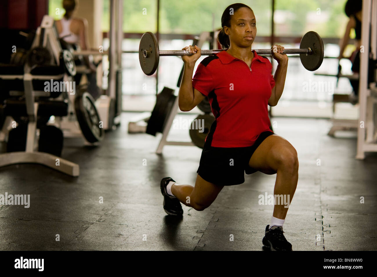 Woman weight lifting in health club Stock Photo