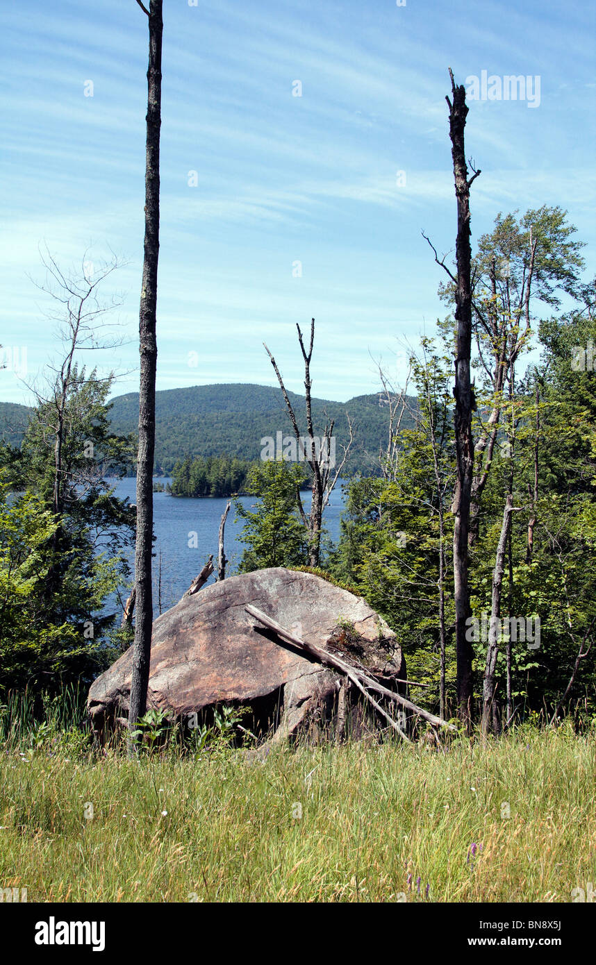 A large rock, trees, lake, island and mountains. An Adirondack scene scenic. Stock Photo