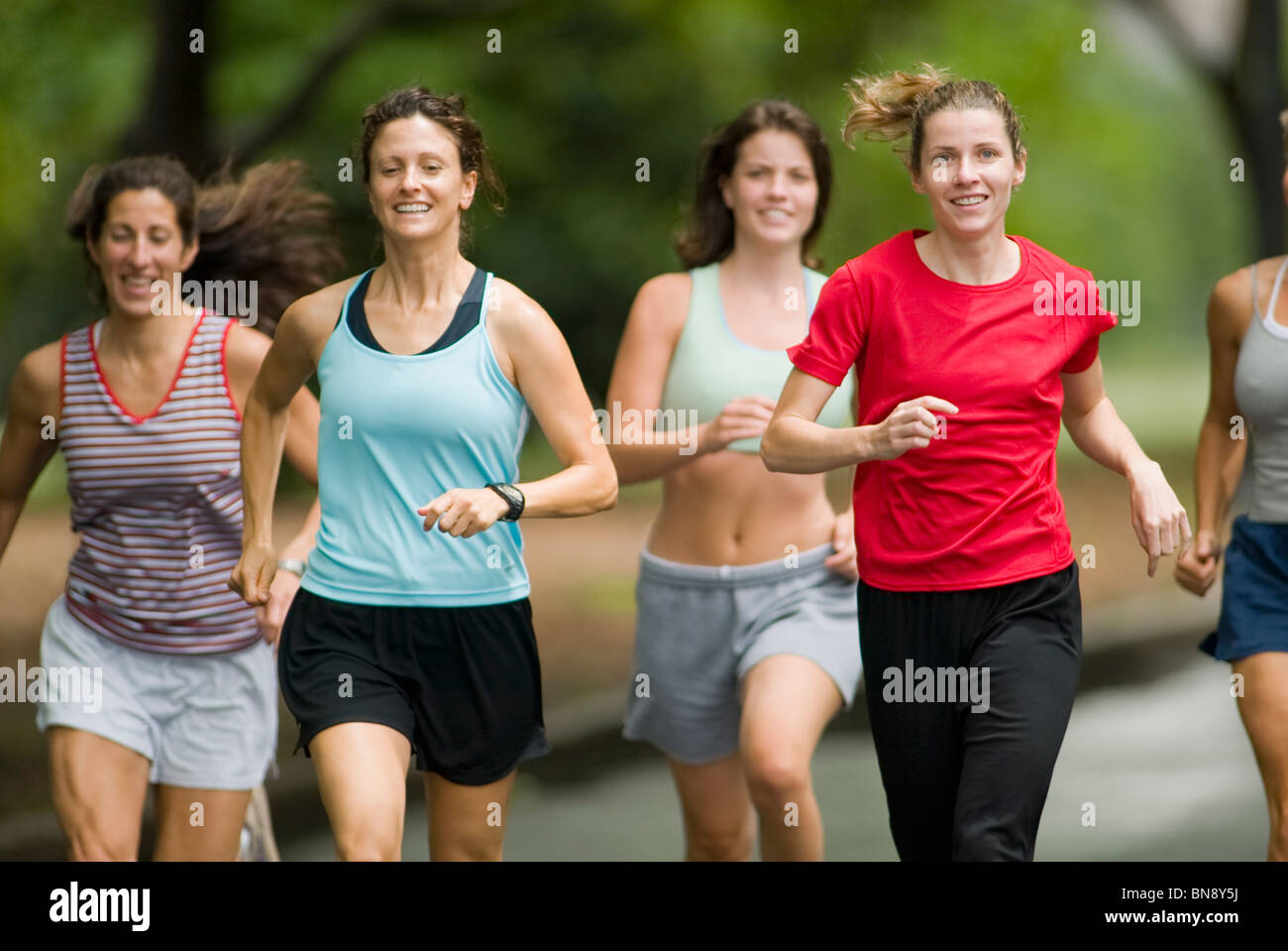 Runners jogging in park Stock Photo