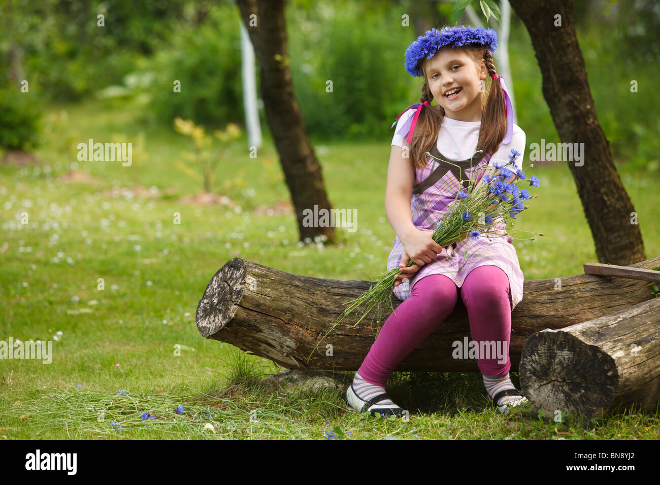 Little girl with a chaplet made from blue flowers Stock Photo