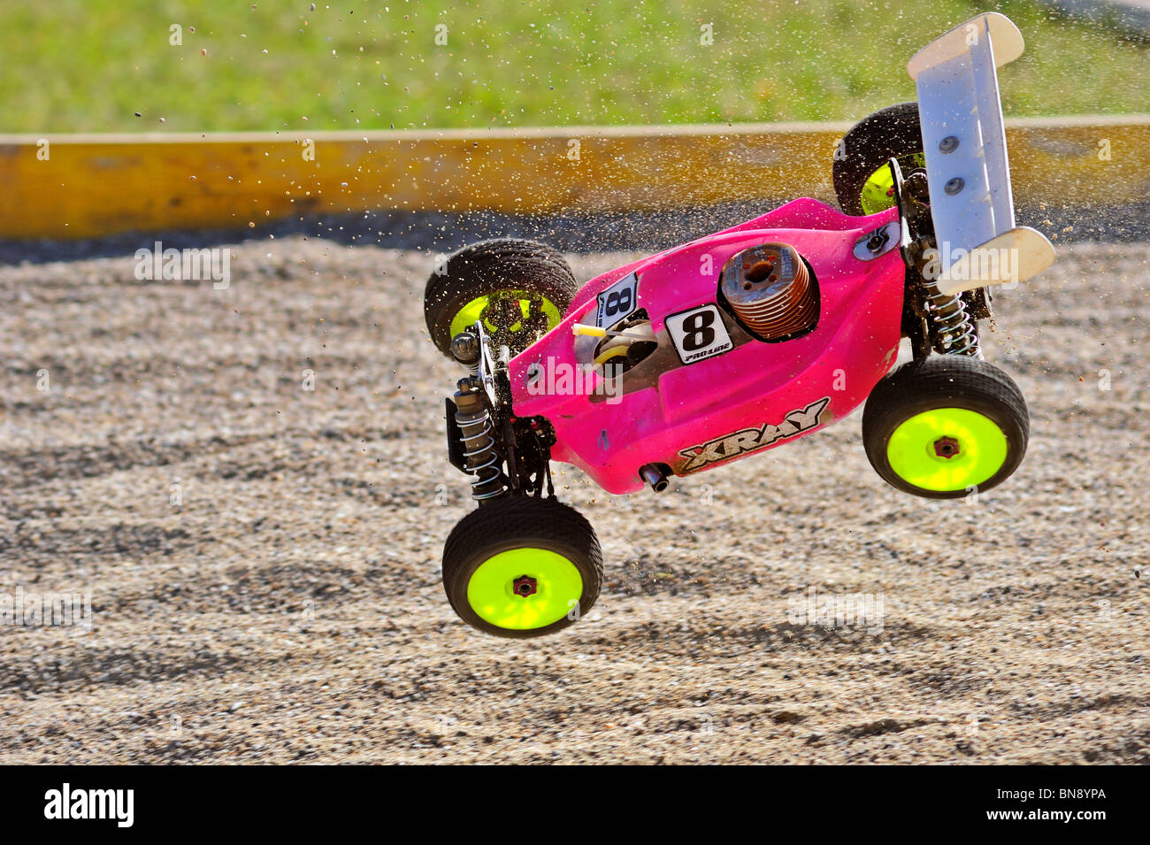 Radio-controlled buggy, racing in the European championships, caught in mid-air at a jump on the course. Stock Photo