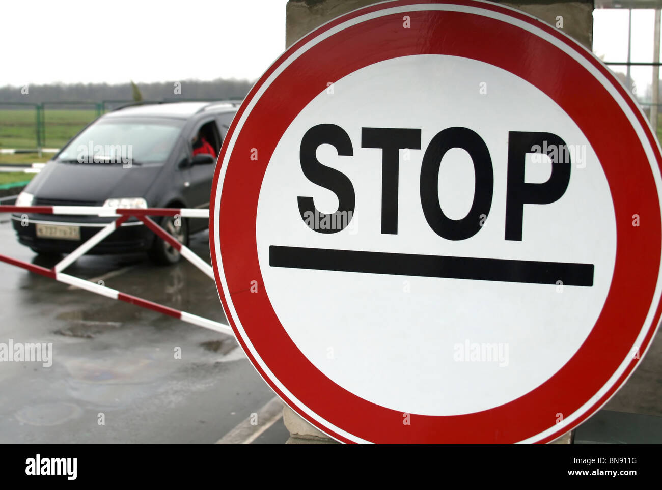 Car behind the stop sign at boundary checkpoint Stock Photo