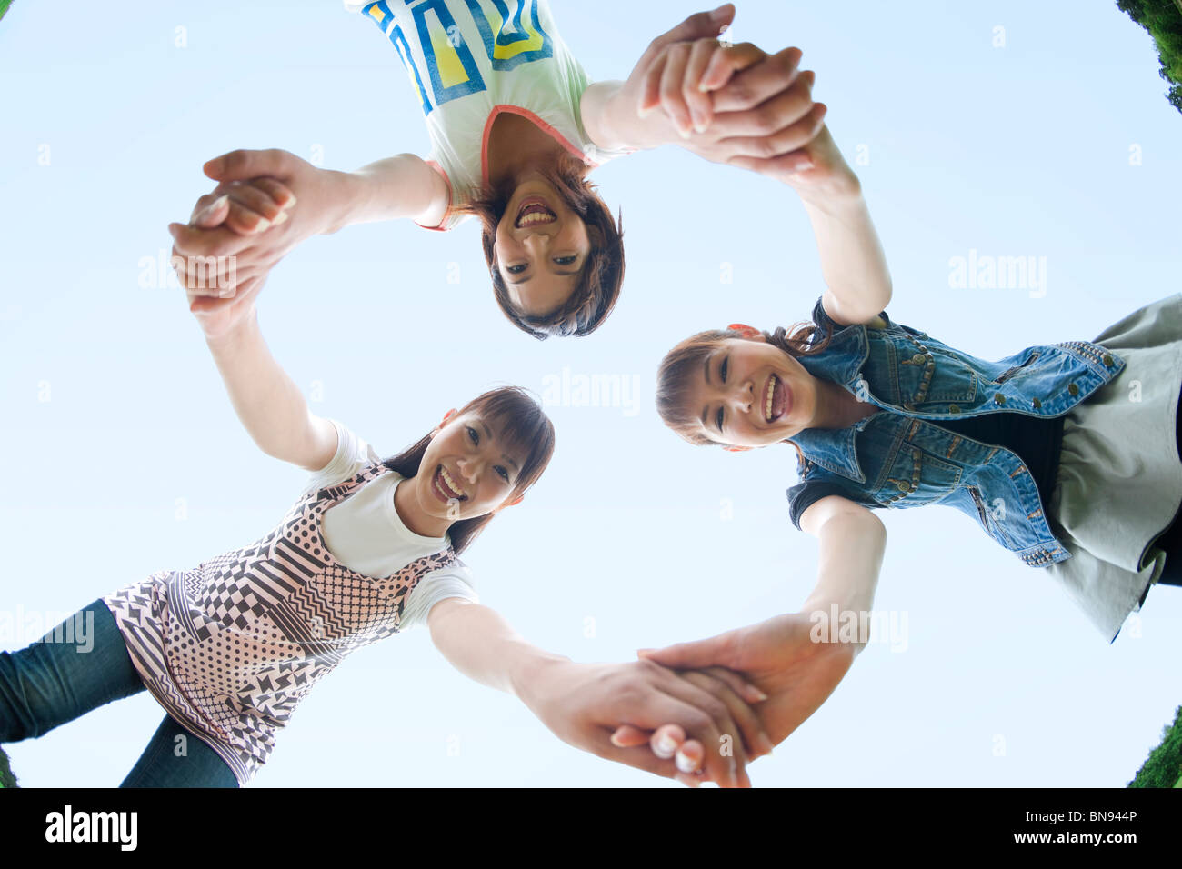 Three Young Women Holding Hands Stock Photo - Alamy