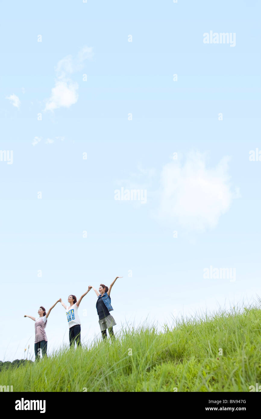 Three Young Women Holding Hands Up Together Stock Photo - Alamy