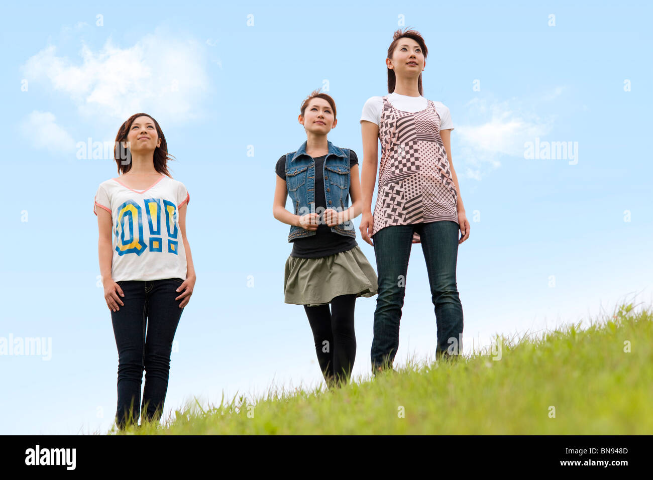 Three Young Women Standing Under Blue Sky Stock Photo - Alamy