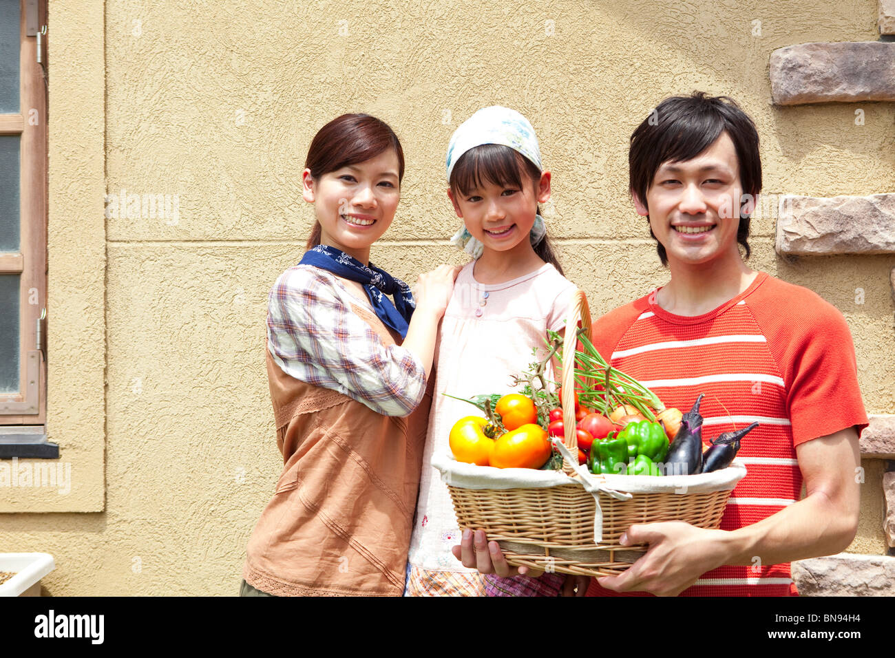 Portrait of family holding basket filled with fresh vegetables Stock ...