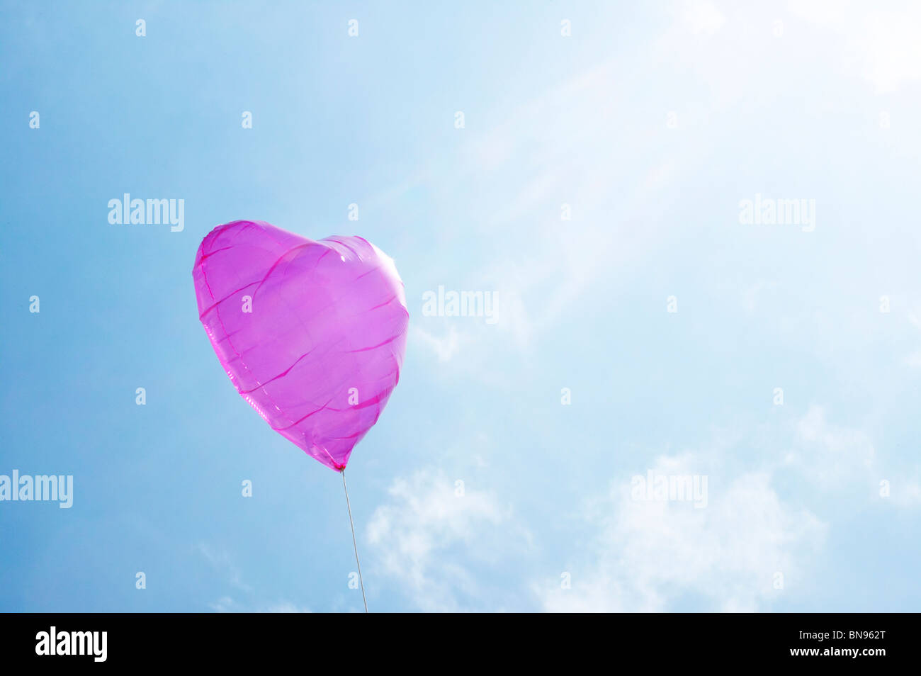 A purple heart shaped balloon floating in the sky Stock Photo - Alamy