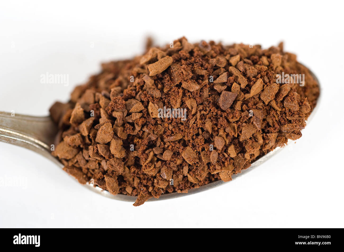 Teaspoon full of instant coffee granules isolated on white Stock Photo