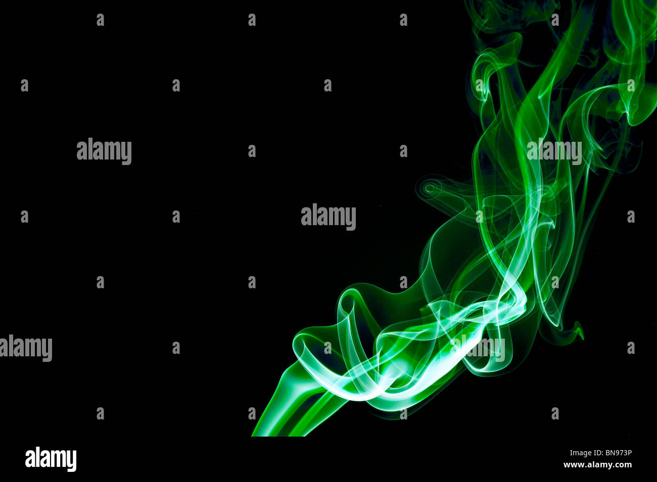 Abstract green smoke trails on a black background Stock Photo - Alamy