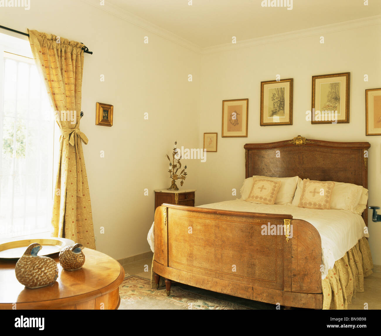 Pictures On Wall Above Antique Mahogany Bed In Neutral Bedroom