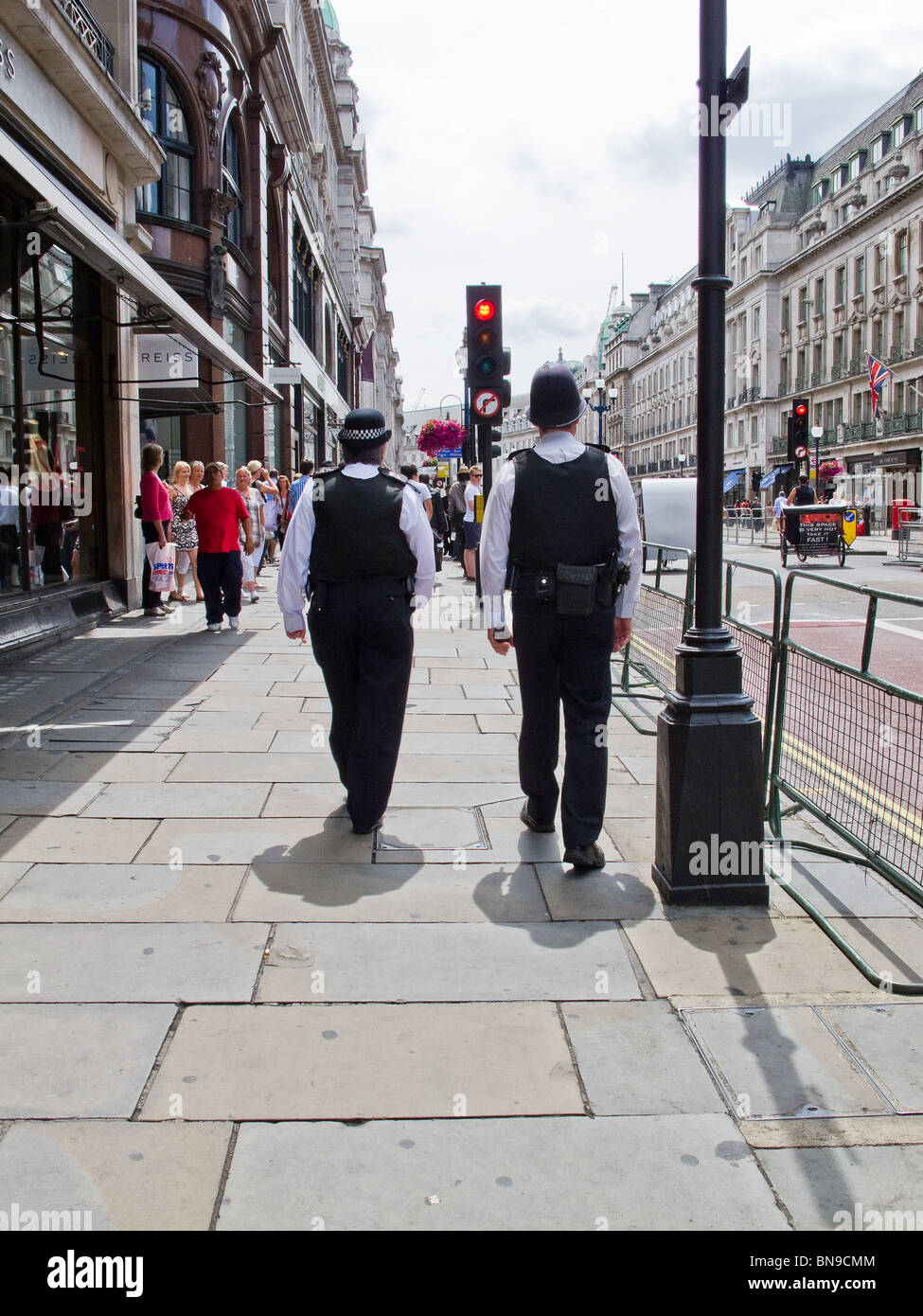 Two Metropolitan police officers walking on a street in London. Stock Photo