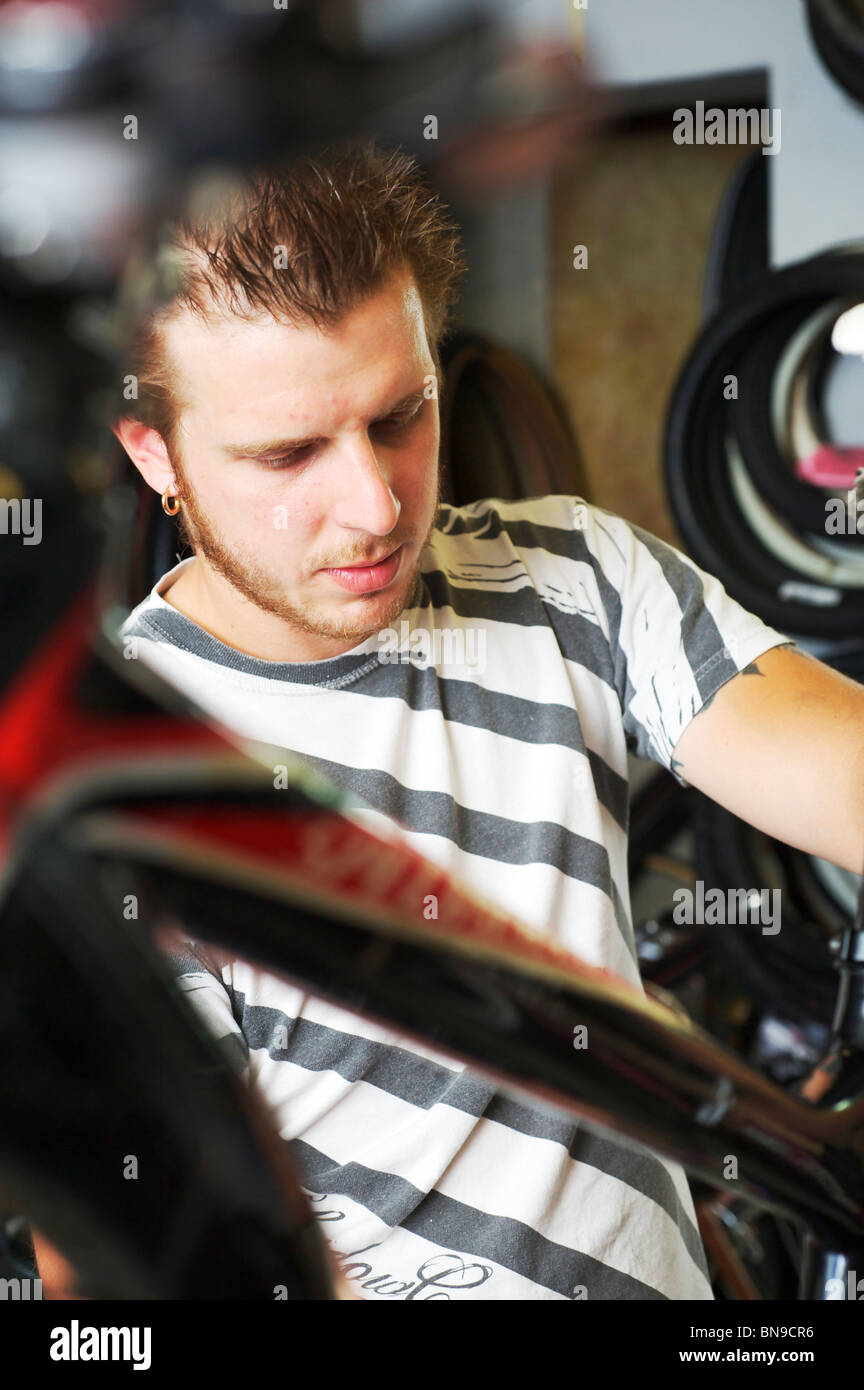 Cycle mechanic fixing racing bike in workshop Stock Photo