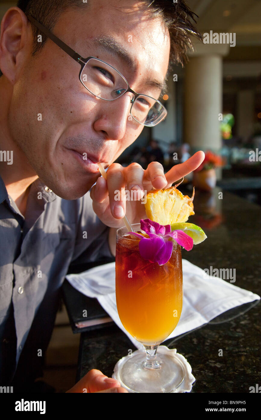 Korean American tourist enjoying a Mai Tai Tropical Drink at Four Seasons Resort in Maui, Hawaii Stock Photo