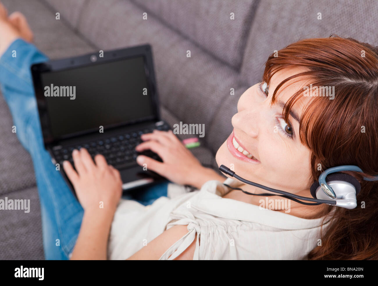 Beautiful young woman at home with a laptop and speaking over the ...