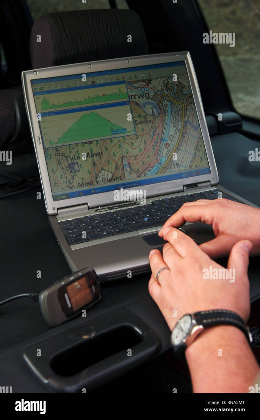 A man plots a route on a laptop from a global positioning system Stock ...