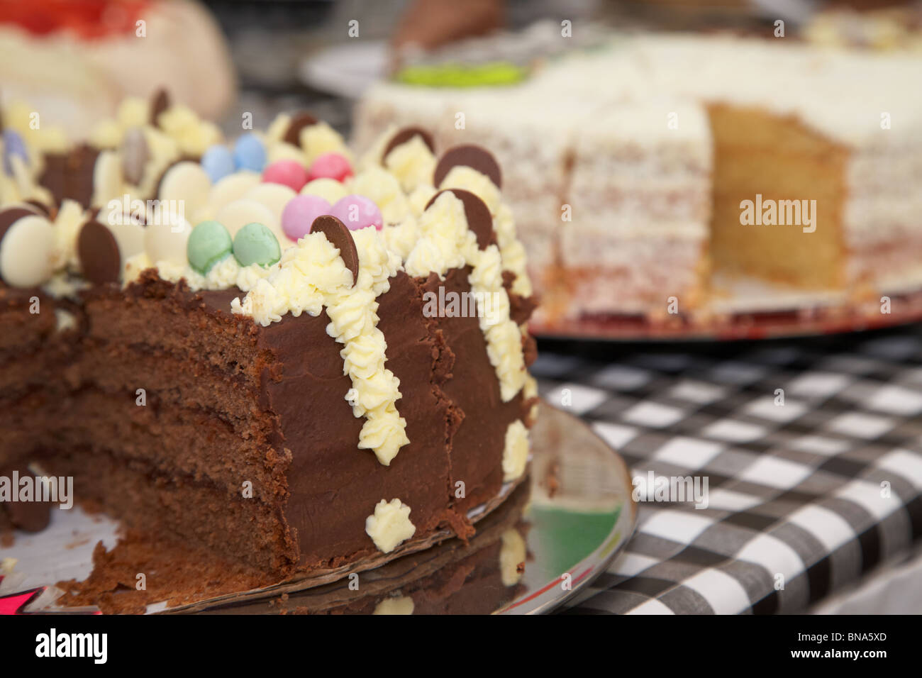 large sliced chocolate cake cakes on table stall market in the uk Stock Photo