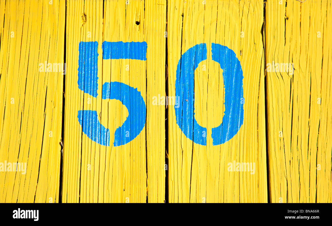 Crystal River, FL - Mar 2009 - The number 50 painted in blue on a bright yellow background on a dock in Crystal River, Florida Stock Photo