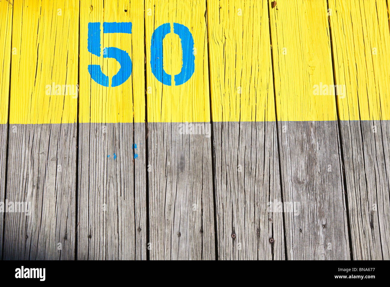Crystal River, FL - Mar 2009 - The number 50 painted in blue on a bright yellow background on a dock in Crystal River, Florida Stock Photo