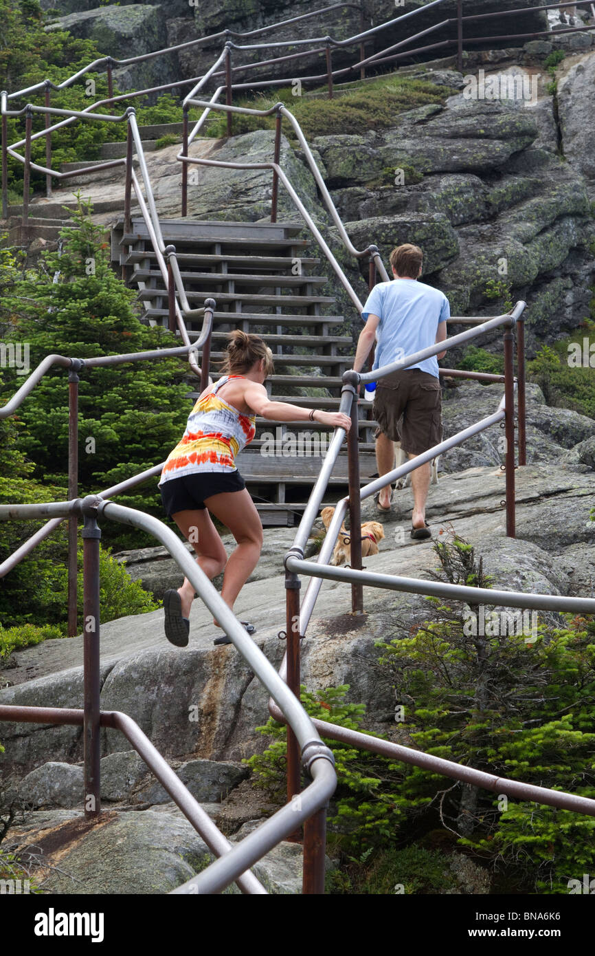 Tourists in various stages of climbing the rock stairs along the ridge ...