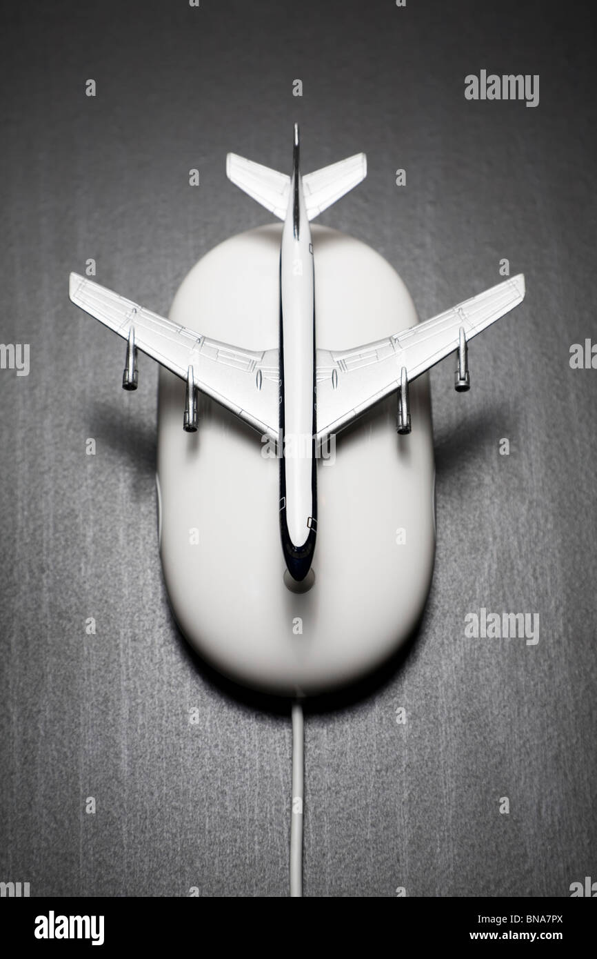 Toy airplane placed on a computer mouse Stock Photo