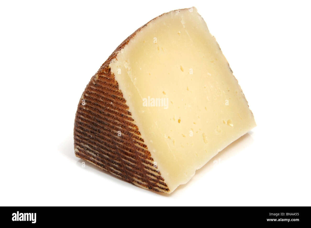 a piece of manchego cheese on a white background Stock Photo - Alamy