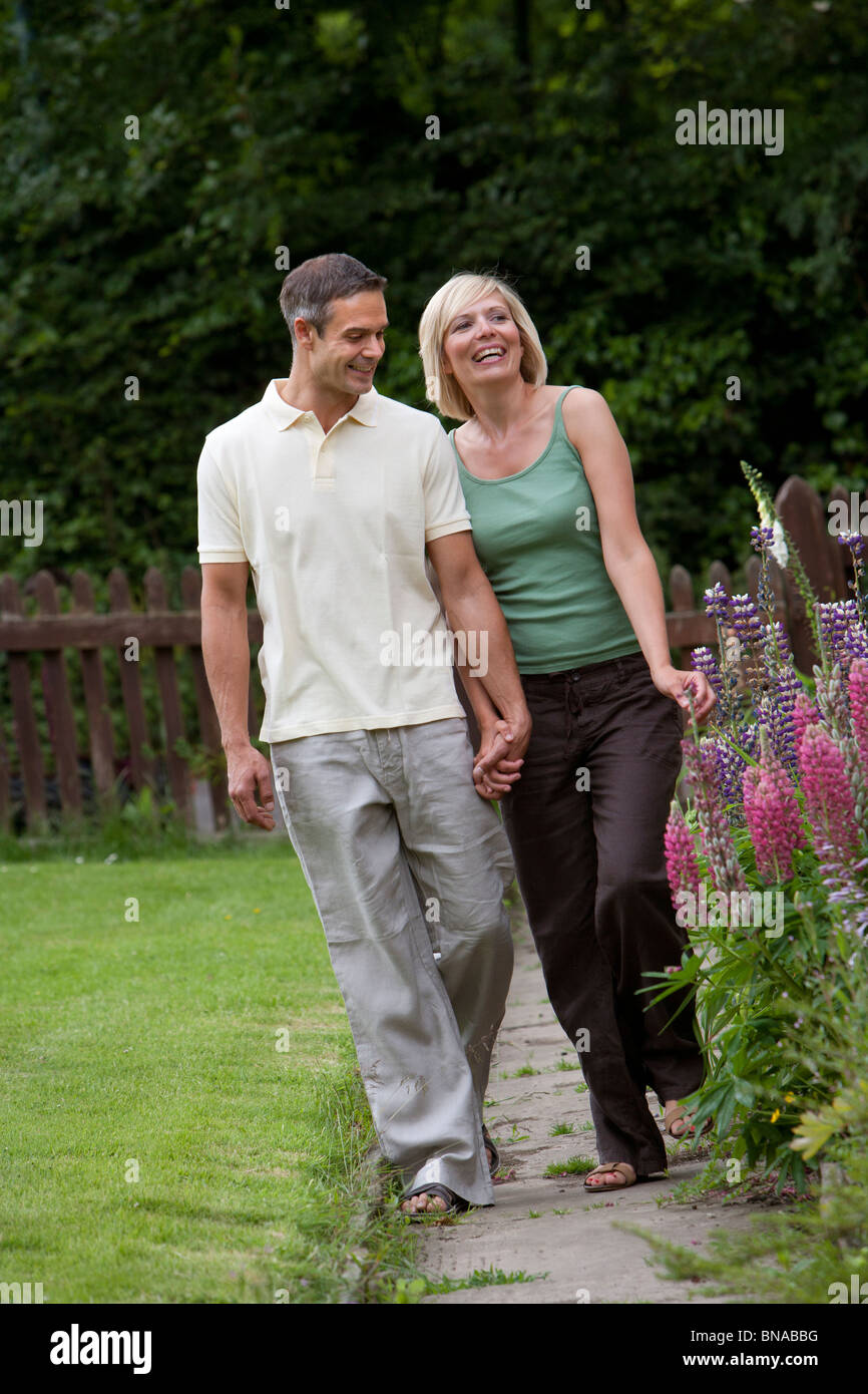 Couple walking up garden path Stock Photo