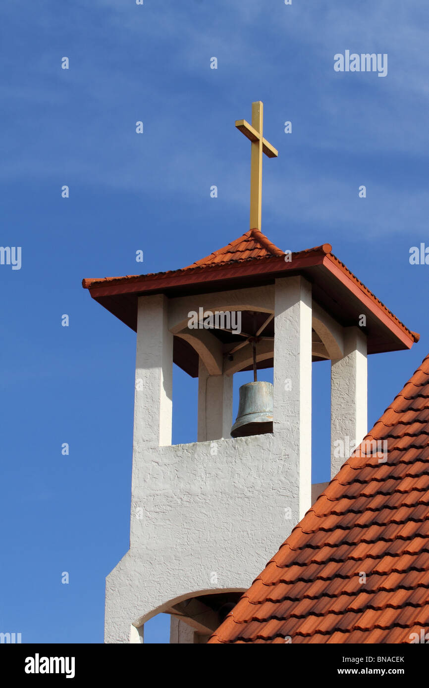 cross at top of church on blue sky Stock Photo
