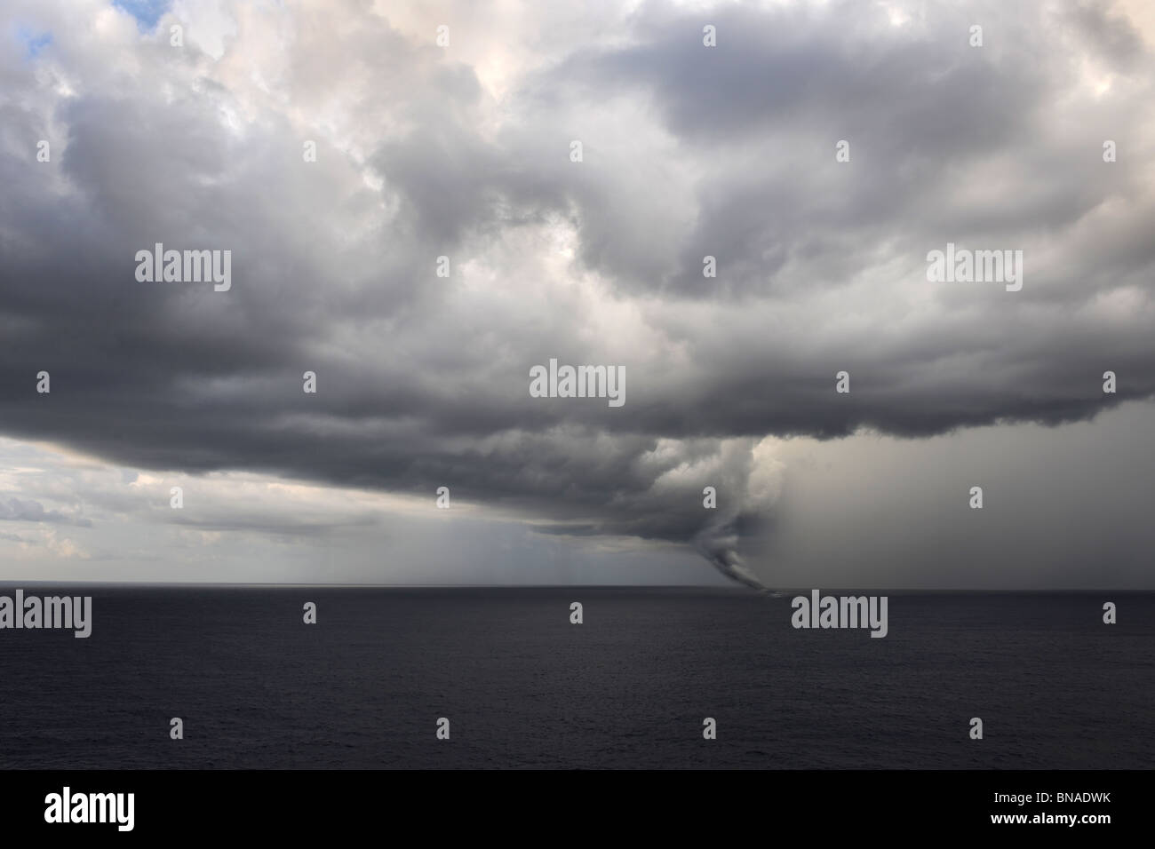Tornado touching down at sea with dark clouds swirling Stock Photo