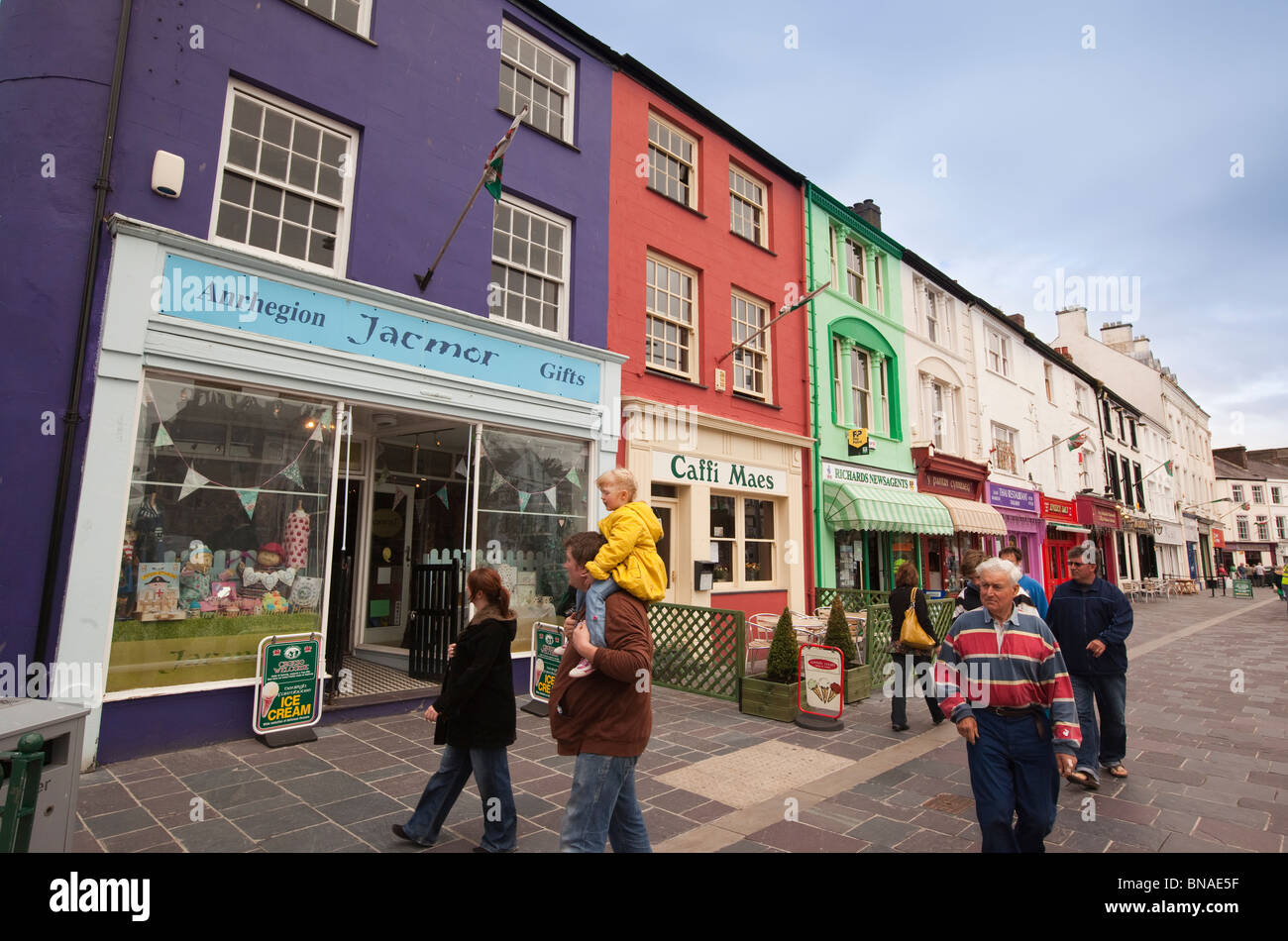 UK, Wales, Gwynedd, Caernarfon, Y Maes, colourfully painted shops opposite the castle Stock Photo