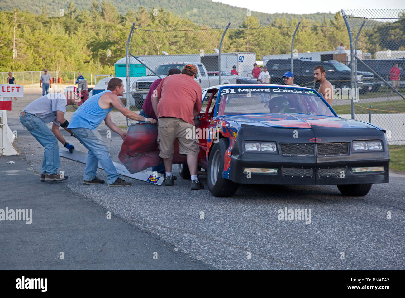 Pit Crew Repairs Damaged Car in Stock Car Race Stock Photo