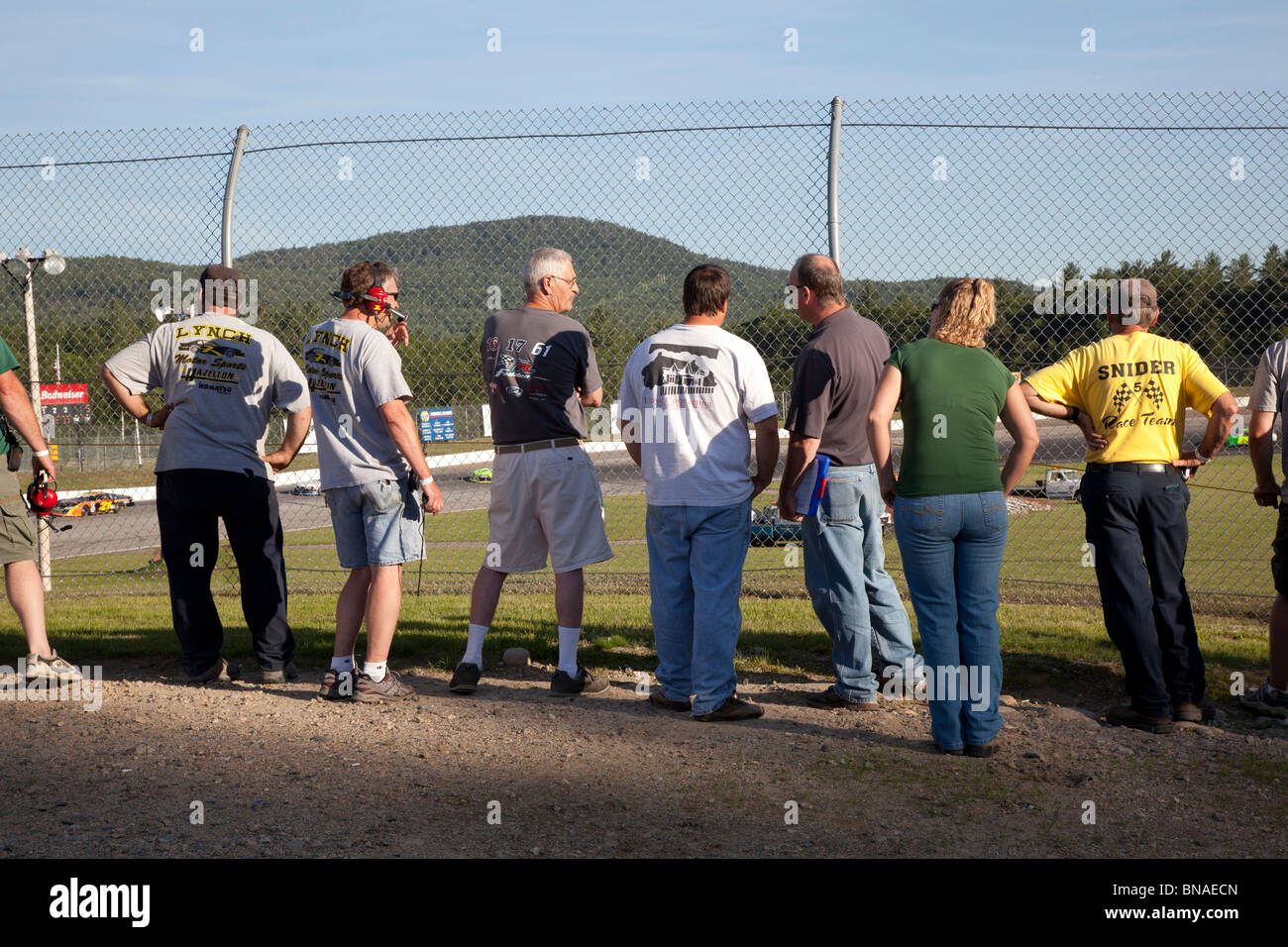 Woodstock, New Hampshire - Pit crew members watch stock car racing at White Mountain Motorsports Park. Stock Photo