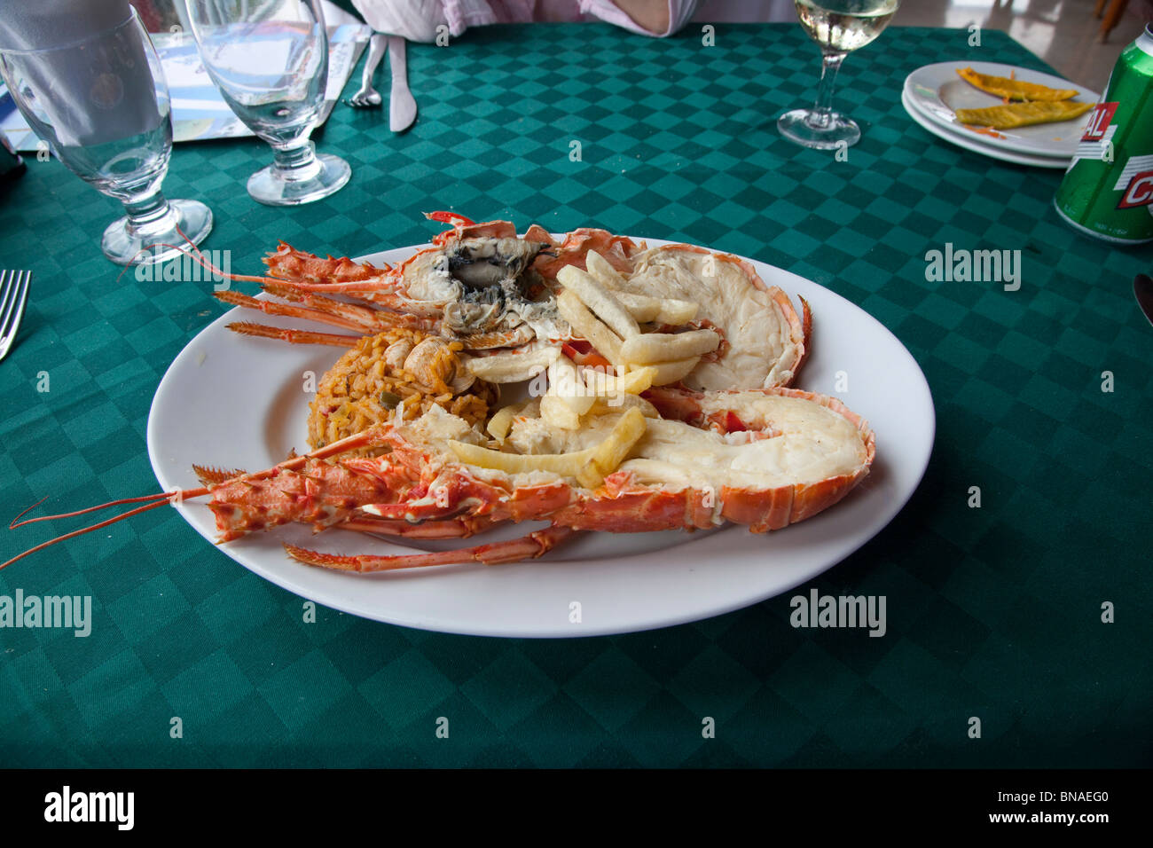 a plate of cooked lobster, fries and rice. Stock Photo