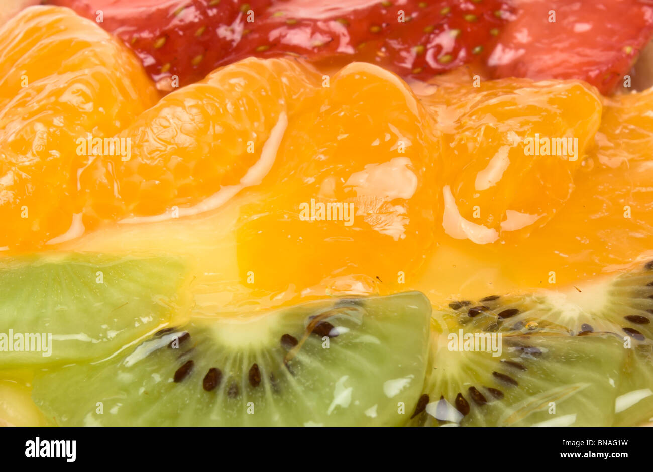 Custard filled tart topped with summer fruits of Strawberry, mandarin orange and kiwi fruit. Stock Photo