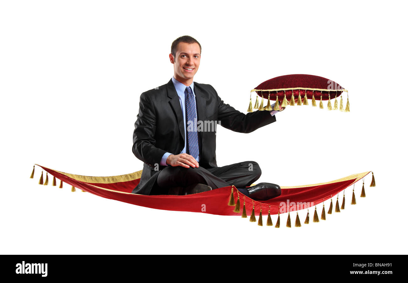 A man holding a pillow while flying on a magic carpet Stock Photo
