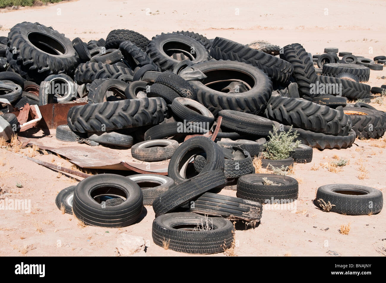 A pile of worn out rubber tires have been dumped in the desert Stock