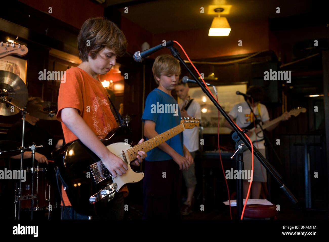 Schoolboys perform rock and roll song together as a band in a south London pub. Stock Photo