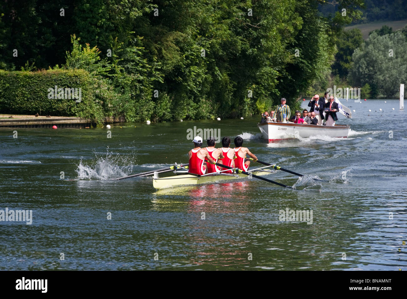 Competitive rowers racing and taking part at  Henley Regatta, a Thames launch with umpires follow closely behind. Stock Photo