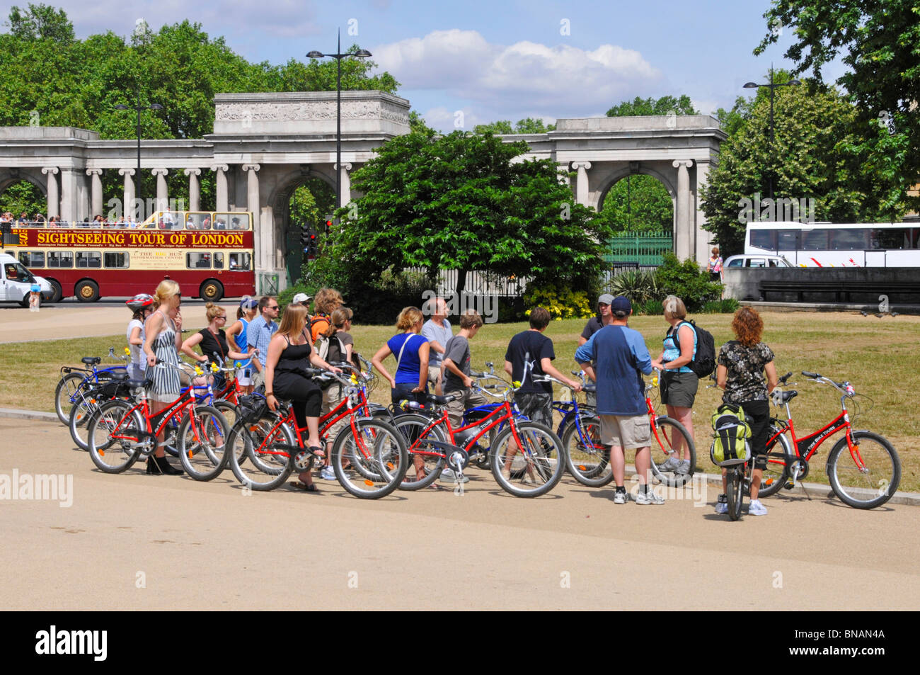Cycle group at Hyde Park Corner chose a escorted bike tour to open top sightseeing tour bus beyond Stock Photo