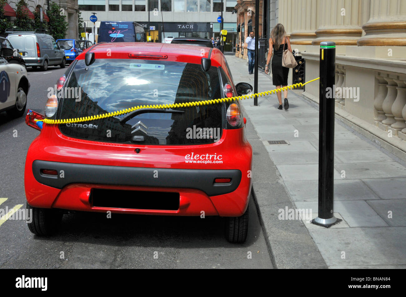 Electric charging cable connects red Citroen car to electric top up bollard juice point by Westminster City Council climate change concerns London UK Stock Photo