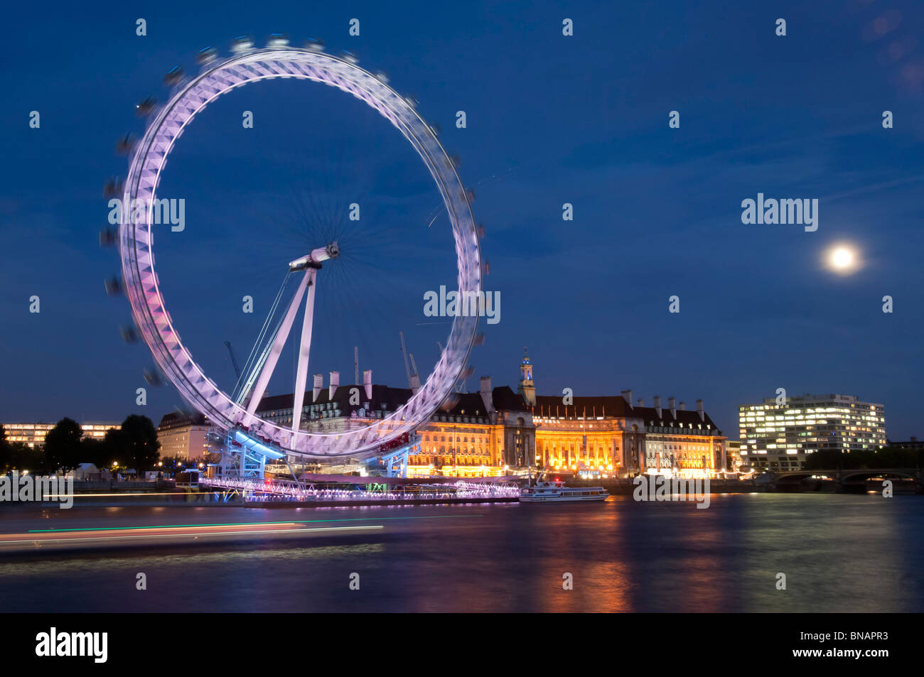 London Eye at night with the moon. Stock Photo