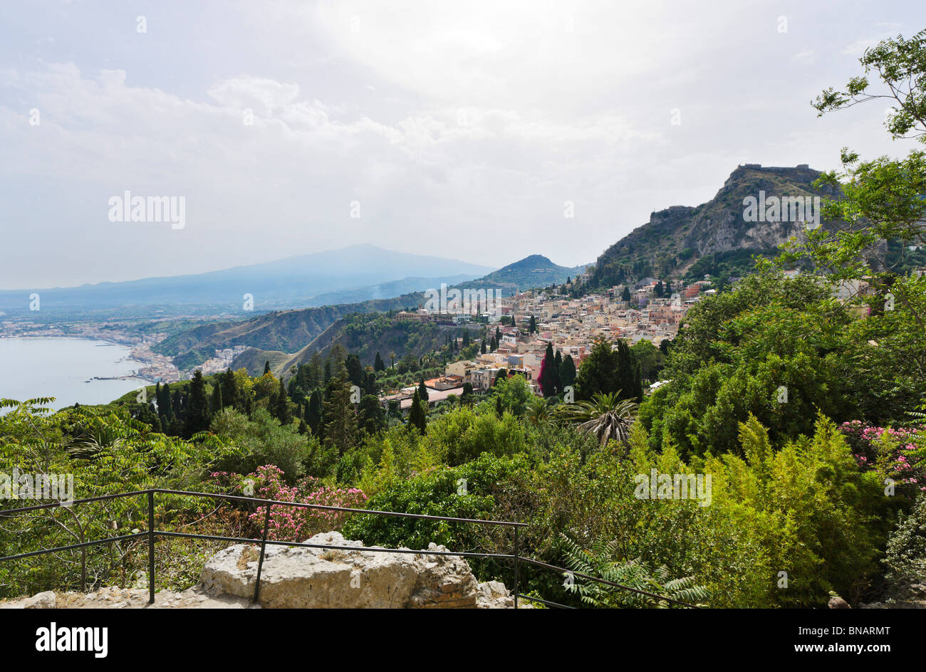 View over Taormina from the Greek Theatre (Teatro Greco) with Mount Etna in the distance, Taormina, Sicily, Italy Stock Photo