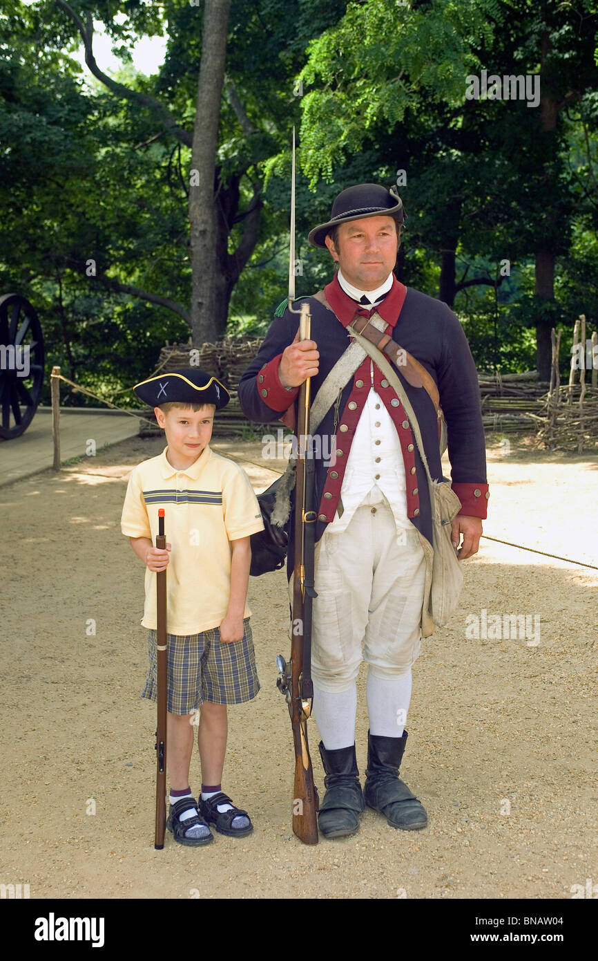 A young visitor poses for a photo with a 1780s Continental Army soldier at Yorktown Victory Center, a living history museum in Yorktown, Virginia, USA Stock Photo