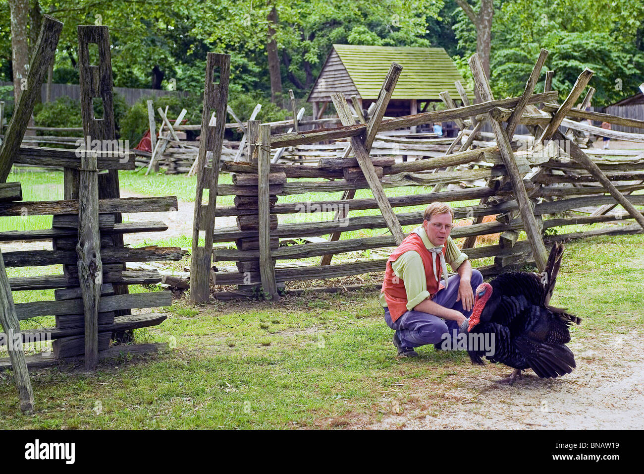 An interpreter and a pet turkey enliven a re-created 1780s farm at the living-history American Revolution Museum in Yorktown, Virginia, USA. Stock Photo