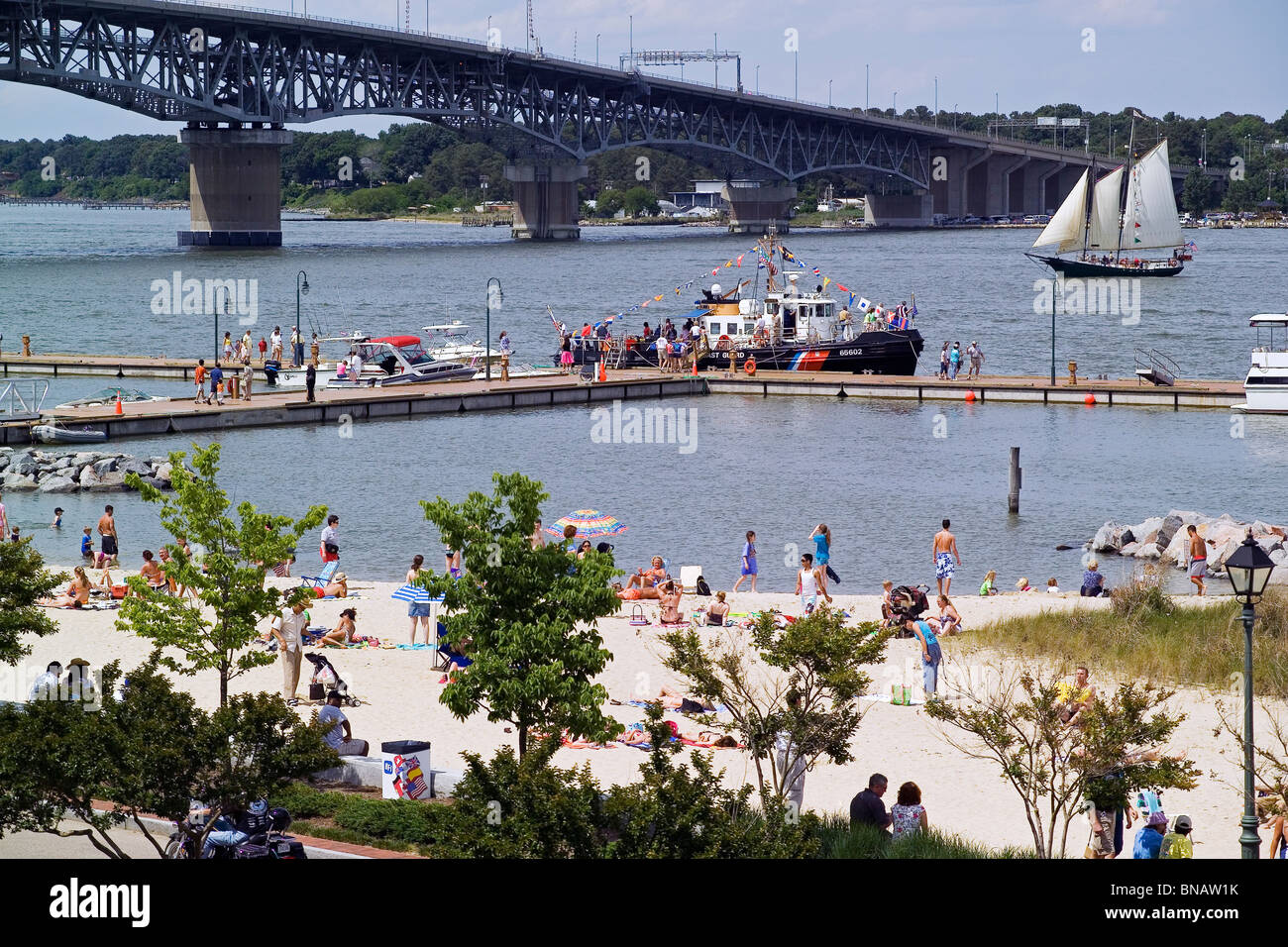 Sunbathers enjoy sandy Yorktown Beach and boaters the York River that is spanned by the Coleman Memorial Bridge at historic Yorktown in Virginia, USA. Stock Photo