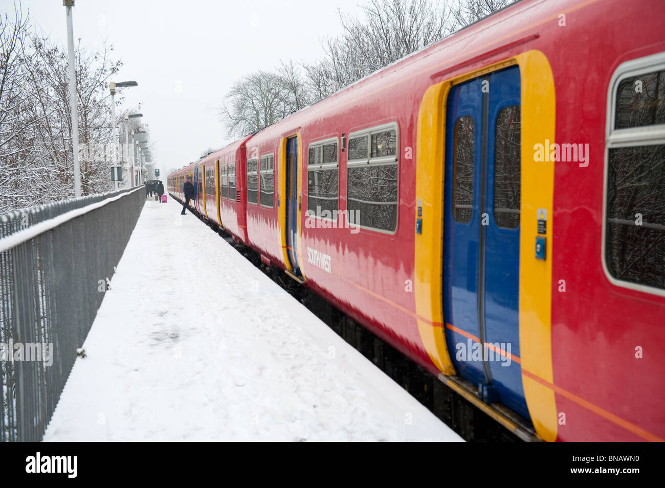 A commuter South West train standing at station on a snowy day Stock Photo