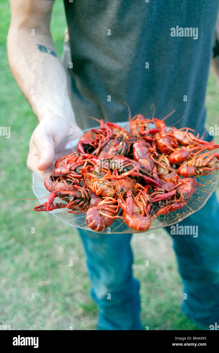 A man holding a plate of homemade spicy, boiled crawfish (or crayfish), in the town of Shreveport, Louisiana, in the southern United States. Stock Photo