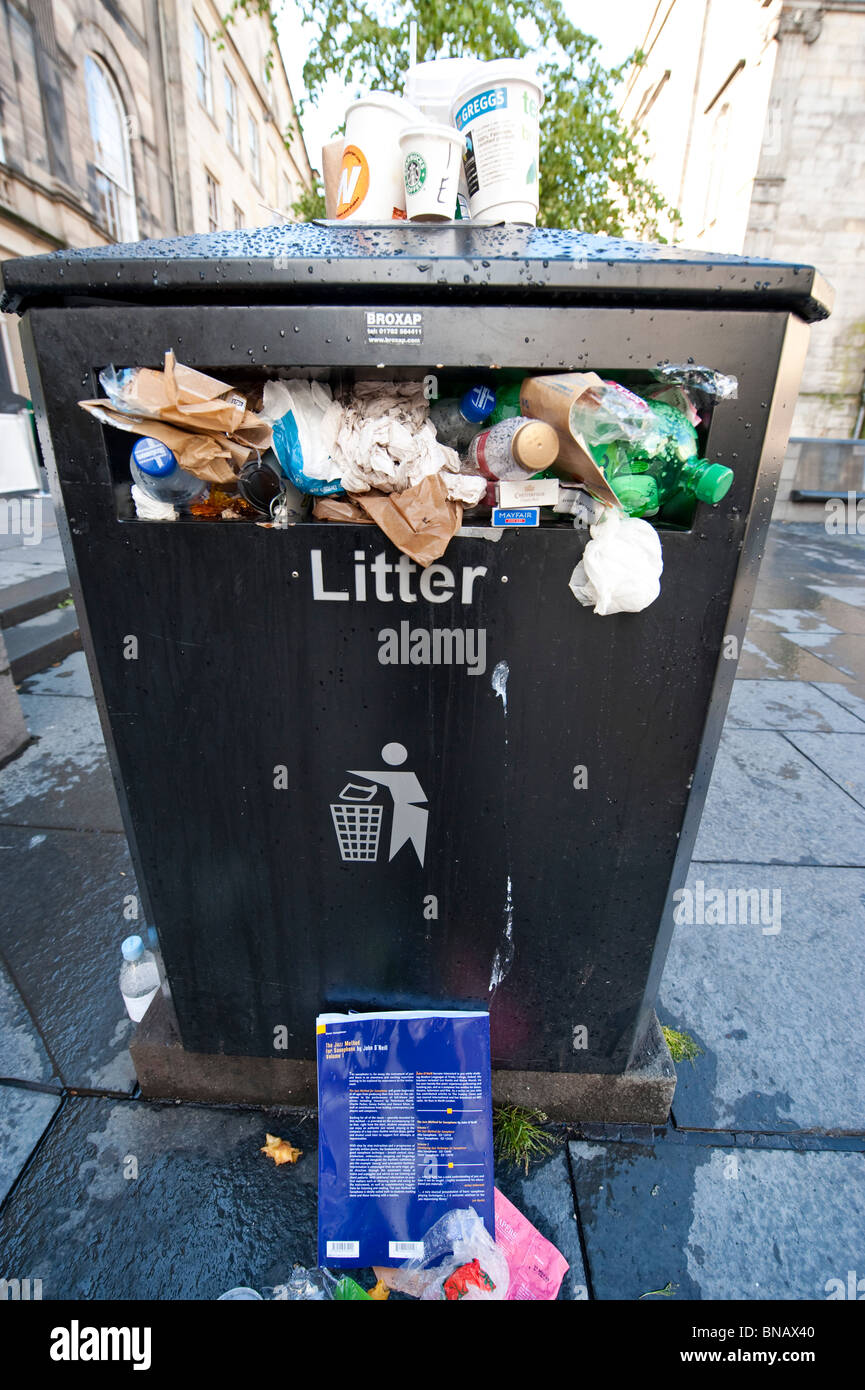 Bin full of of rubbish and litter on the pavement Stock Photo Alamy