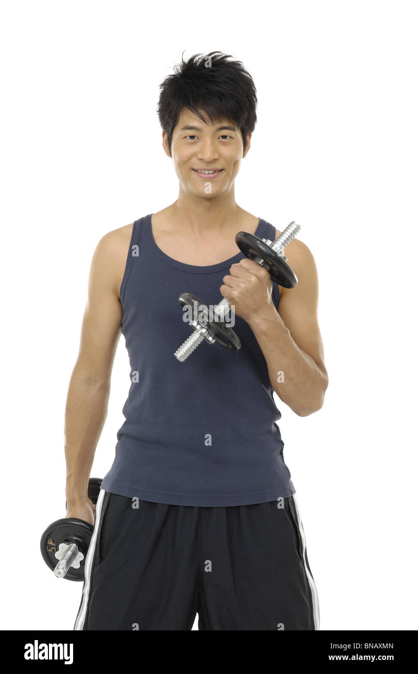 Young man exercising with dumbbells Stock Photo